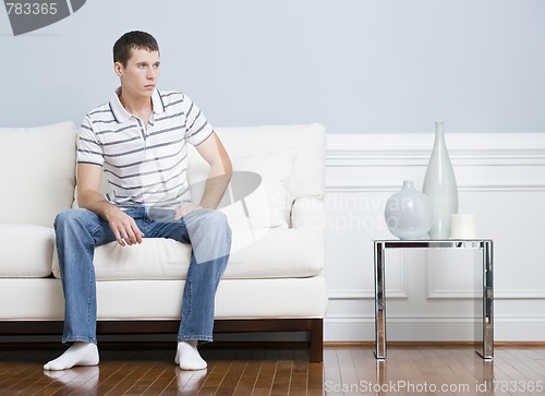 Image of Man Sitting on Living Room Couch