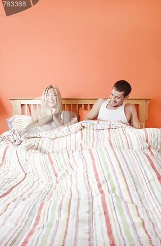 Image of Young Couple Lying in Bed Laughing