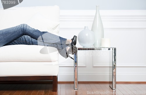 Image of Woman's Leg's Reclining on White Couch