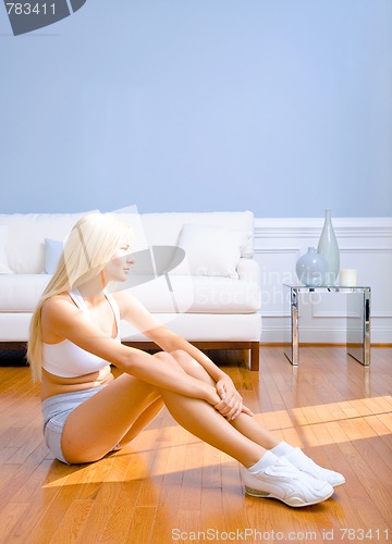 Image of Young Woman Sitting on Wood Floor