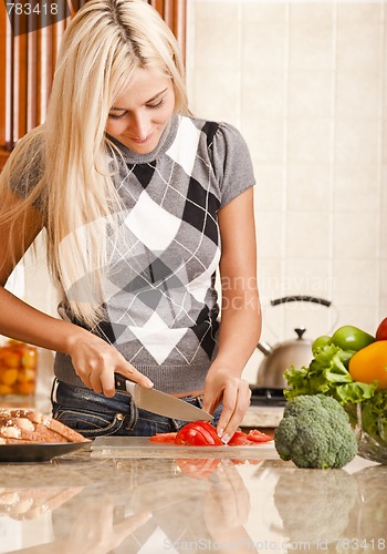 Image of Young Woman Cutting Tomato