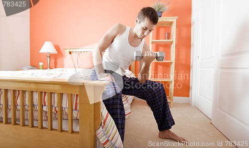 Image of Man Using Arm Weight in Bedroom
