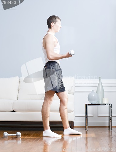 Image of Man Using Arm Weights in Living Room