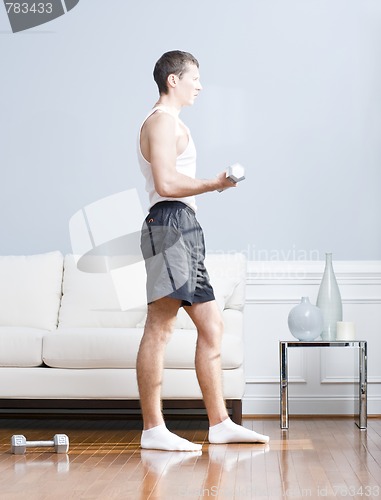 Image of Man Using Arm Weights in Living Room