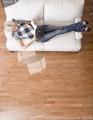 Image of Overhead View of Woman Reading on Couch