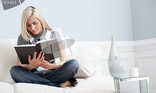 Image of Woman Sitting on Couch and Reading a Book