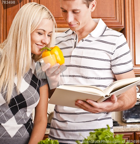 Image of Young Woman Smelling Pepper Held by Young Man