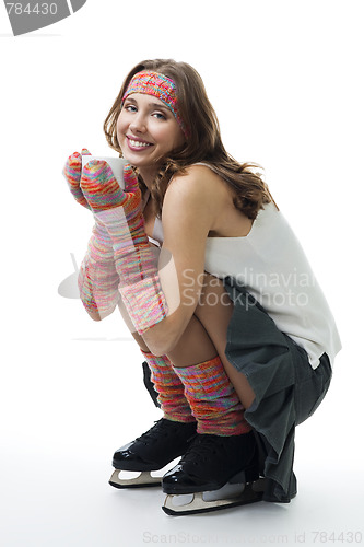 Image of Woman in ice skates sit with cup of coffee