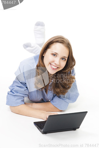 Image of Happy woman lay on the floor with laptop