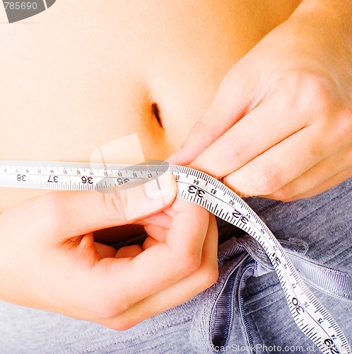 Image of Young Woman Measuring Herself On White