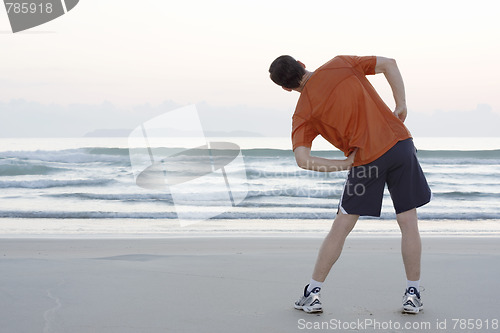 Image of Jogger doing stretching on a beach