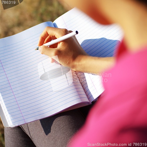 Image of Girl Writing in Note Book