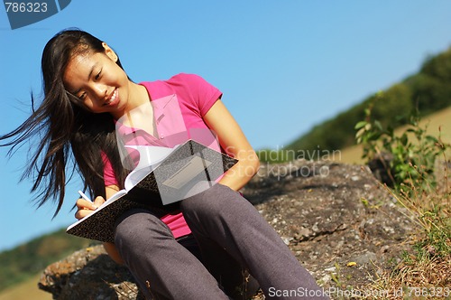 Image of Girl Writing in Note Book