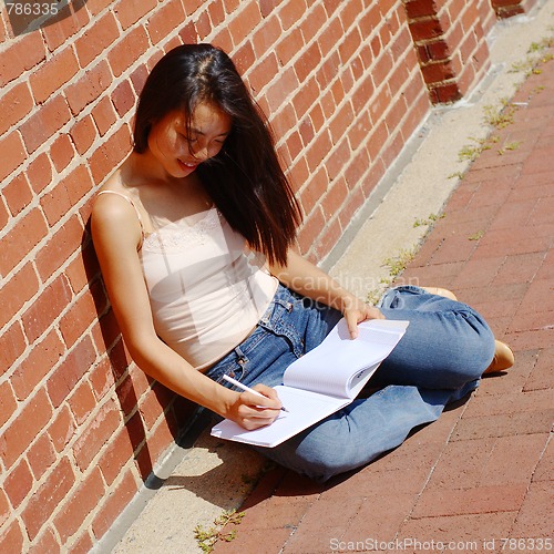 Image of Girl Writing In Note Book