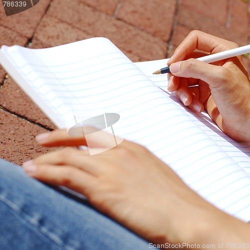 Image of Girl Writing In Note Book