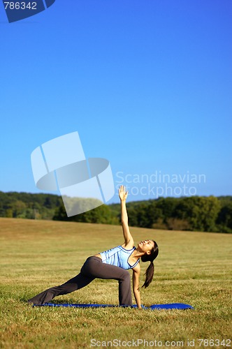 Image of Girl Practicing Yoga In Field