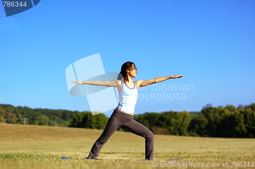 Image of Girl Practicing Yoga In Field