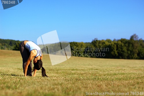 Image of Girl Practicing Yoga In Field