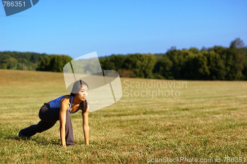 Image of Girl Practicing Yoga In Field