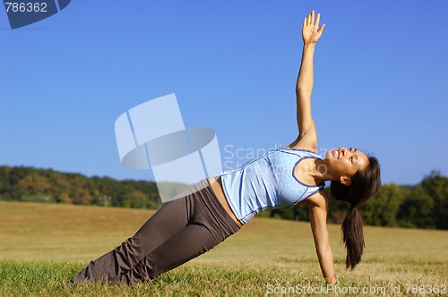 Image of Girl Practicing Yoga In Field