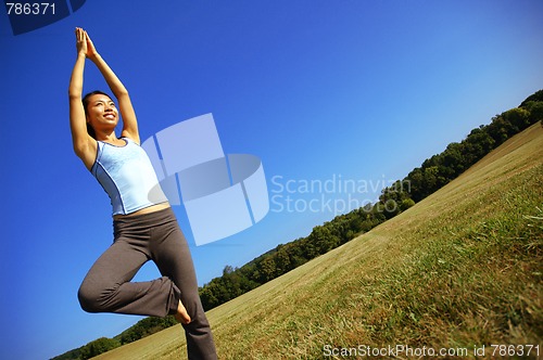 Image of Girl Practicing Yoga In Field