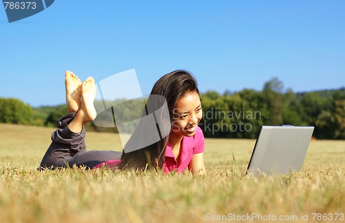 Image of Girl on Laptop in Meadow