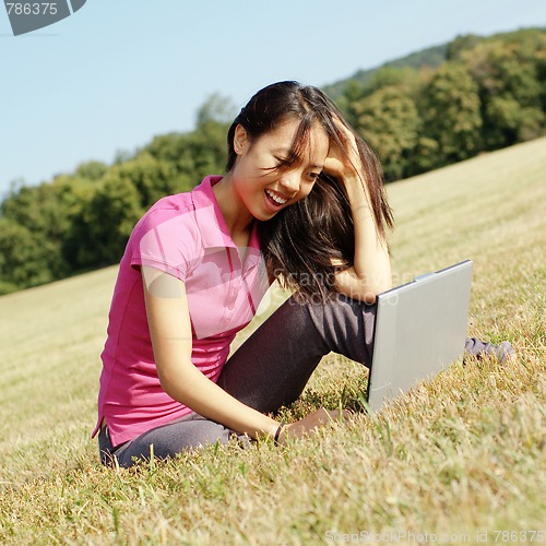 Image of Girl on Laptop in Meadow