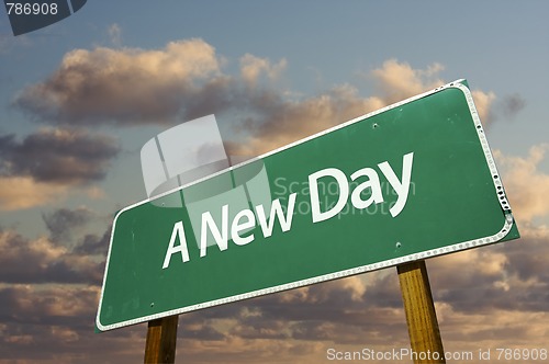 Image of A New Day Green Road Sign with dramatic clouds and sky.
