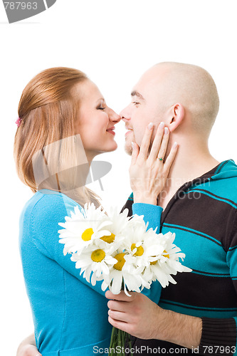 Image of Couple kissig holding flowers