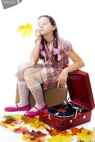 Image of  kid sitting holding maple leaf with gramophone