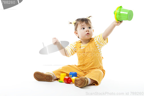 Image of Kid play sit and with toys, holding pail