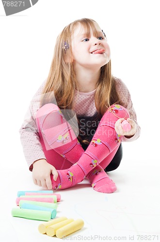 Image of Little girl with chalks stick her tongue out