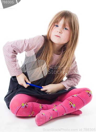 Image of Little girl sit with felt pen with intense face