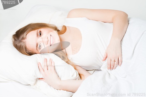 Image of Positive young woman in bed