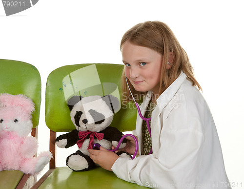 Image of girl playing doctor with her toys