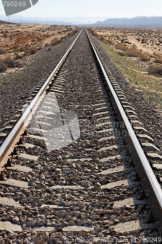 Image of Straight railway in the desert converging to the horizon