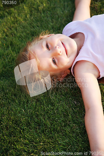 Image of Happy girl relaxing on a grass