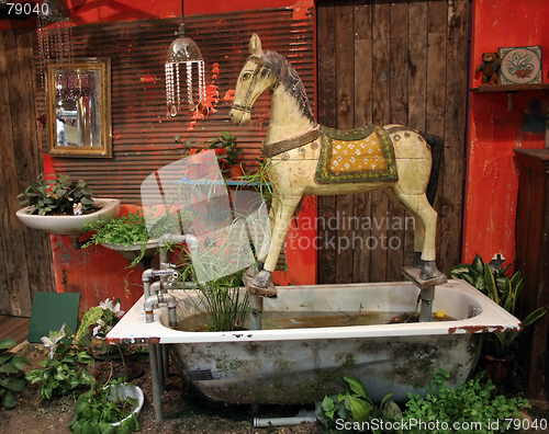 Image of Antique wooden horse set in old bathtub