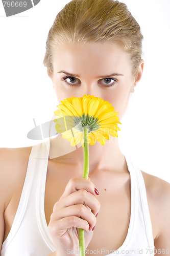 Image of young woman smelling a yellow flower