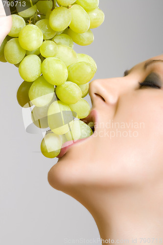 Image of woman biting grapes