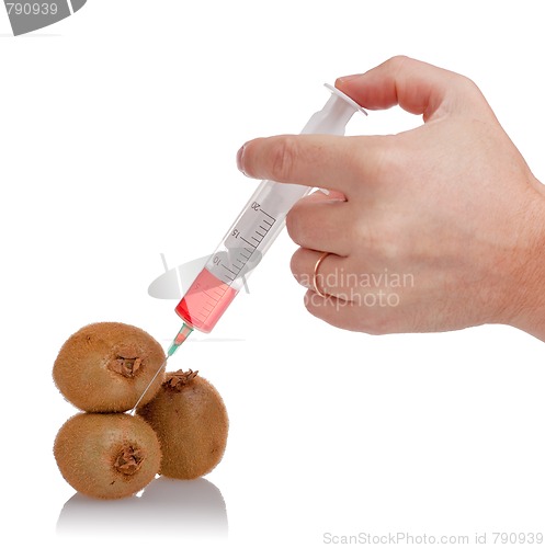 Image of  hand holds the syringe on kiwi