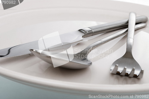 Image of empty plate, fork, spoon and table-knife