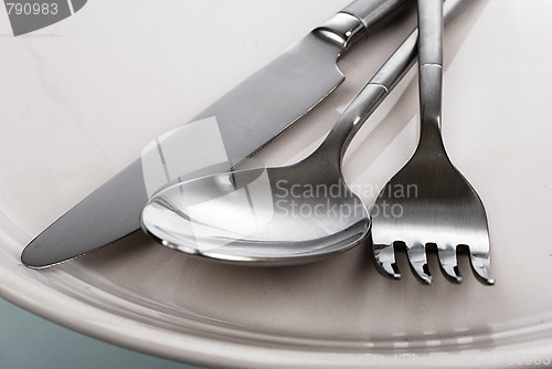 Image of empty plate, fork, spoon and table-knife