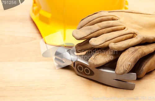 Image of Yellow Hard Hat, Gloves and Hammer on Wood