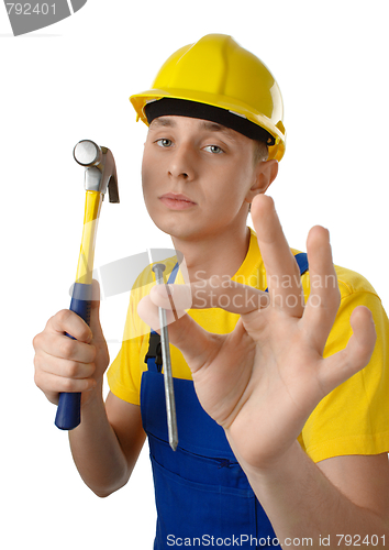 Image of Young serene worker with hammer and nail