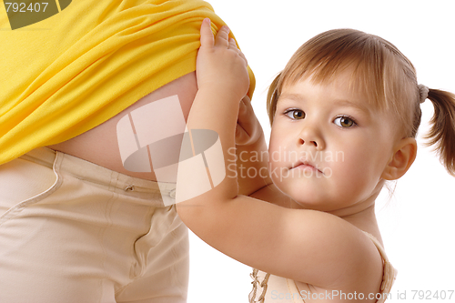 Image of Daughter looking at pregnant mother's belly