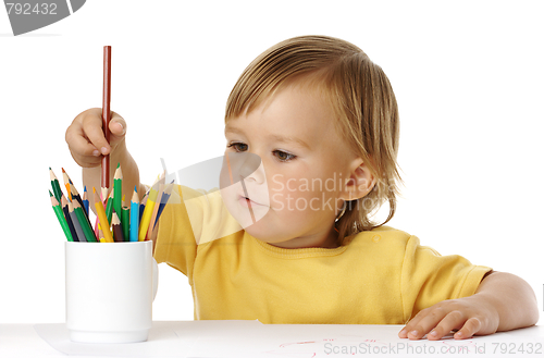 Image of Child picking a crayon from the cup