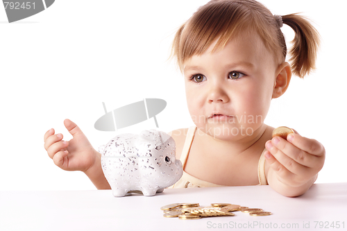 Image of Cute little girl with piggybank