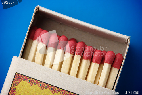 Image of Red matchsticks in the box on blue background
