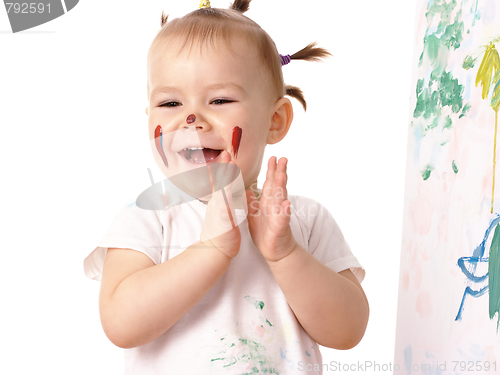 Image of Little girl play with paints, clapping her hands